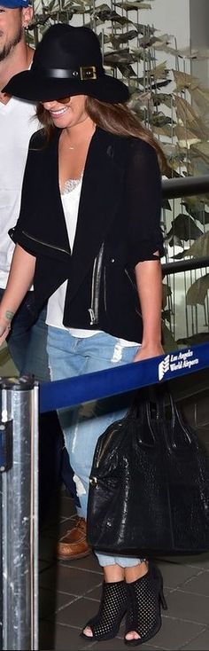 a man and woman standing next to each other at an airport