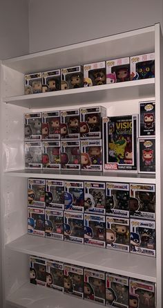 a white shelf filled with lots of different types of pop vinyls on top of it