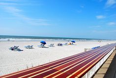 the beach is lined with lounge chairs and umbrellas