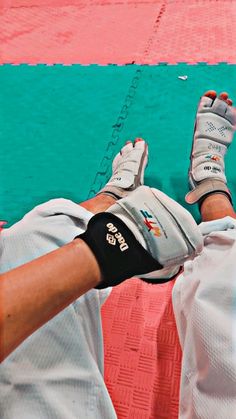 a baseball player laying on the ground with his feet propped up in batting gloves and pads