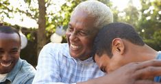 two men hugging each other in front of trees