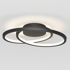 two circular lights that are connected to each other on a ceiling mounted fixture in an empty room