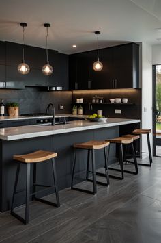 a kitchen with black cabinets and wooden stools in front of the counter top is an island that has three bar stools on it