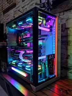 a computer case sitting on top of a wooden table in front of a brick wall