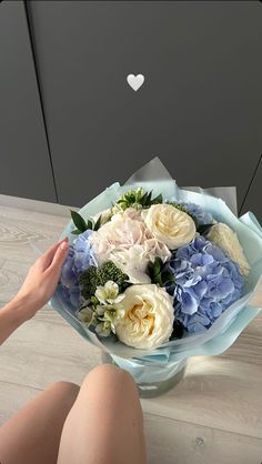 a woman sitting on the floor holding a bouquet of flowers