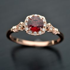 a close up of a ring with a red stone