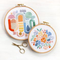 two embroidery hoops with scissors on top of them