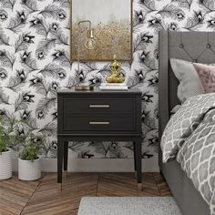 a bedroom with black and white wallpaper, gold accents and a nightstand in front of the bed