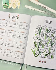 an open planner with flowers on it next to markers and pencils in front of the calendar