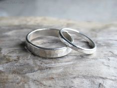 two wedding rings sitting on top of a rock