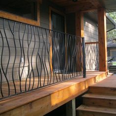 a wooden porch with wrought iron railing and steps