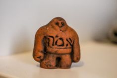 an old clay figurine with the word koon written on it