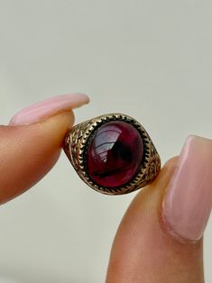 Pre Loved 9ct Yellow Gold Cabochon Garnet Large Signet Ring  Wonderful glowing garnet with sweet engraved shoulders The item comes without the box in the photos but will be presented in an Howard's Antique gift box   Measurements: weight 4.59g, size UK O US 71/2, head of ring 14mm x 12mm, height off finger 5mm  Materials: 9ct yellow gold and garnet  Hallmarks: hallmarked 375 Condition : The overall condition is very good office use: DH2 Red Cabochon Signet Ring Gift, Collectible Red Gemstone Signet Ring, Antique Red 14k Gold Signet Ring, Gold Garnet Rings With Cabochon, 14k Gold Cabochon Red Ring, Antique Gift, Chain Pendants, Signet Ring, Class Ring