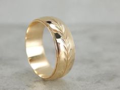 a gold wedding ring with leaves on it