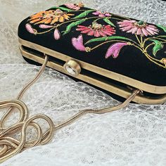 Turn heads wearing this colorful floral embroidered black velvet evening clutch bag. Be bright and bold! This exclusive design is expertly hand embroidered by master zardozi artisans. Each petal and leaf is outlined with glittery metallic gold threads and embellished with genuine semi precious stones, including garnets, turquoise, carnelian and onyx. Shop sustainably - own a handbag of exceptional quality that you will keep forever and pass down to the next generation. View more exclusive embroi Festive Floral Embroidery Evening Bag, Evening Clutch With Floral Embroidery For Festive Occasions, Festive Evening Clutch With Floral Embroidery, Festive Floral Embroidered Evening Clutch, Festive Floral Embroidery Evening Clutch, Embroidered Velvet Rectangular Evening Bag, Luxury Black Clutch For Festive Occasions, Multicolor Embroidered Clutch For Evening, Luxury Floral Embroidery Clutch For Party