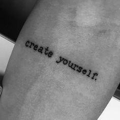 a person with a tattoo that says create yourself on their arm and the words are written in cursive font