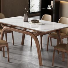 a dining room table with chairs around it and a vase on the table next to it