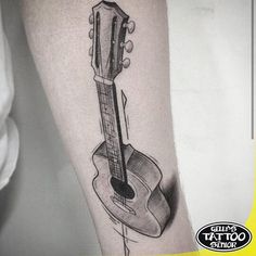 a black and white photo of a guitar tattoo