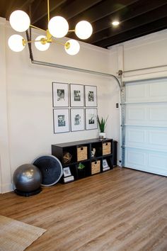 a living room with hard wood floors and pictures on the wall above it's storage unit