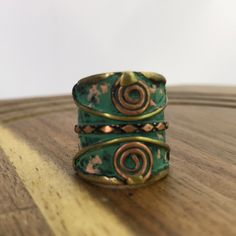 two rings sitting on top of a wooden table next to each other and one has a spiral design on it