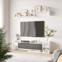 a flat screen tv mounted to the side of a white wall in a living room