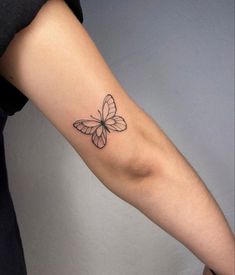 a woman's arm with a butterfly tattoo on the left side of her arm