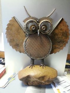 an owl sculpture sitting on top of a rock