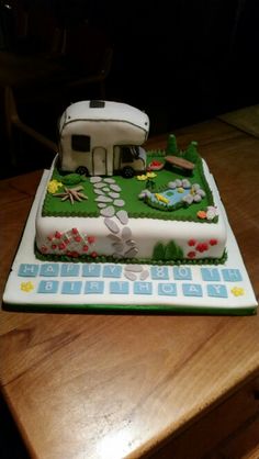 a cake that is sitting on top of a wooden table in the shape of a camper