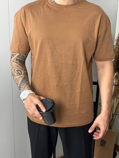 Oversized t-shirts for men are characterized by their relaxed, loose fit, offering a more casual and comfortable style compared to traditional t-shirts. Typically, these shirts have a wider cut and longer sleeves, often extending beyond the shoulders and hips. Popularized by streetwear and casual fashion trends, oversized t-shirts can be styled with jeans, shorts, or layered with jackets. They're known for their comfort and laid-back vibe, making them a staple in modern, casual wardrobes. Jeans Tshirt, Casual Fashion Trends, Jeans Brown, Oversized T Shirts, Brown Tshirt, Tshirt Men, T Shirt Oversize, Comfortable Style, Men Fashion Casual Outfits