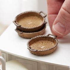 a hand is pointing at two small baskets