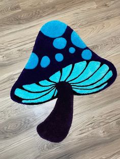 a blue and black mushroom rug sitting on top of a wooden floor