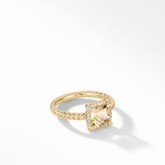 a yellow gold ring with a square cut diamond in the center and pave diamonds on each side