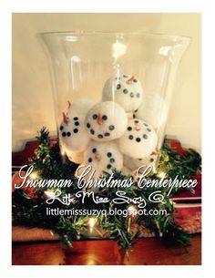 snowman ornaments in a glass vase on a table