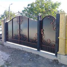 an iron gate is shown in front of a yellow brick wall and concrete block walls