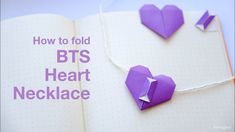 an open book with some origami hearts on it and the title how to fold bts heart necklace