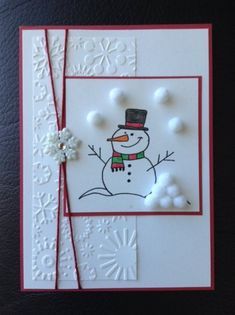 a card with a snowman drawn on it and some buttons attached to the front