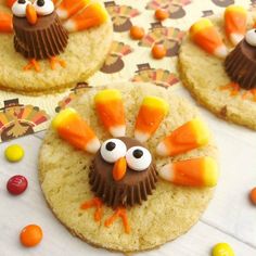 four cookies decorated like turkeys with candy candies around them on top of a table