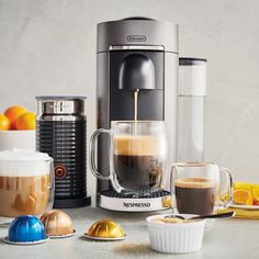 an espresso machine is being filled with coffee and oranges on the table