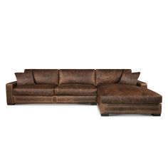 a brown leather sectional sofa with pillows on it's back and footrests