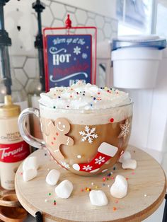 hot chocolate with marshmallows and whipped cream in a glass mug on a wooden table