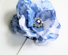 Lapel Pin, Boutonniere, Silk Flower Pin  DESCRIPTION: This gorgeous blue floral taffeta fabric Boutonniere adds a touch of luxury to men's suits, and jackets. Great for formal occasions or as a fun accessory for your favorite blazer or suit. It's not just another boutonniere, but this lovely high quality accessory features:    * Beautiful Blue Floral Fabric Flower Hand-sewn (measures approx. 3 inches in diameter) * The center of the flower is adorned with a Genuine Sapphire Swarovski Crystal sur Groomsmen Black, Lapel Pins Wedding, Usher Gifts, Flower Boutonniere, Fur Pom Pom Beanie, Fur Pom Pom Hat, Flower Lapel, Groomsmen Boutonniere, Flower Lapel Pin