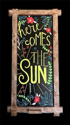 a sign that says, we come to the sun on a black background with flowers and leaves