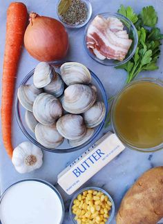 an assortment of food is displayed on a marble counter top, including eggs, corn, carrots, and other foodstuffs