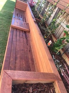 a wooden bench sitting in the middle of a garden