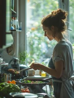 a woman is cooking in the kitchen and looking out the window