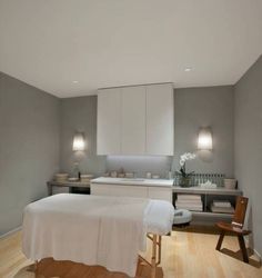 a white bed sitting next to a kitchen on top of a hard wood floor