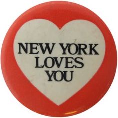 a red and white button with the words new york loves you