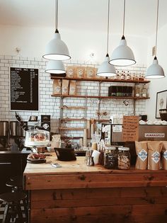 a coffee shop filled with lots of different types of items and lights hanging from the ceiling