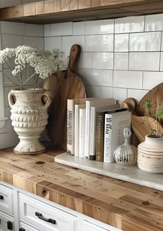 a kitchen counter with books and vases on it