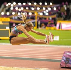 a woman is jumping in the air on a track